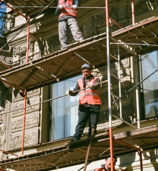 Men on brown scaffolding